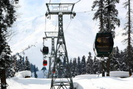 Skiers and tourists ride in a gondola lift, passing over the snow-covered slopes of the famous Gulmarg ski resort in Baramulla district, Jammu and Kashmir, India, on February 12, 2023. The gondola lift offers views of the Himalayan mountains and provides access to higher reaches for winter sports enthusiasts. (Photo by Nasir Kachroo/NurPhoto via Getty Images)